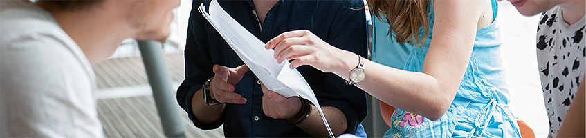 Studierende beim gemeinsamen Lernen mit Unterlagen in der Hand
